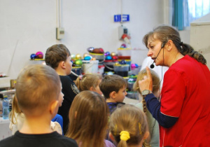 dzieci słuchają przewodniczki po Fabryce Bombek