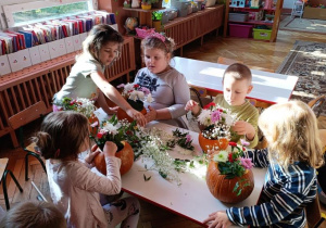 dzieci wykonują ozdoby z dyni